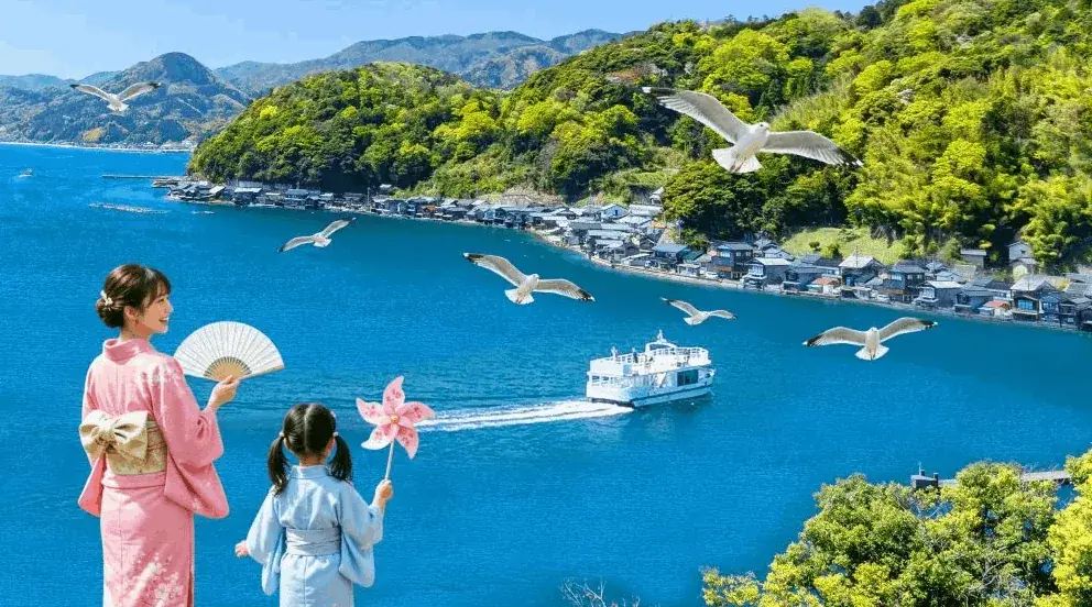 島々と客船が見える海辺で扇子と風車を手にした浴衣の子どもたち